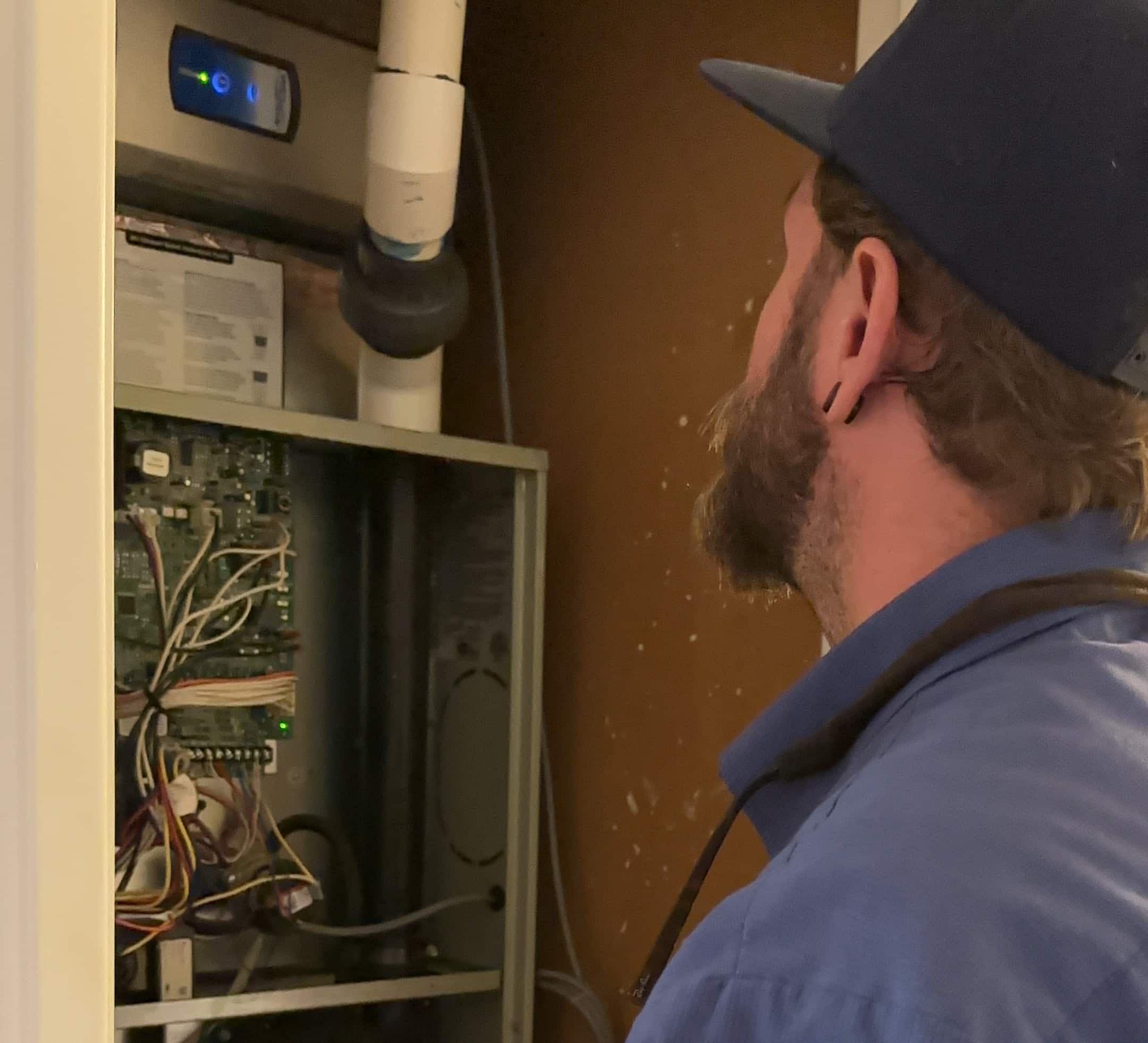 Close-up of a furnace unit with visible damage, such as loose panels, cracked ductwork, and malfunctioning components causing noises.