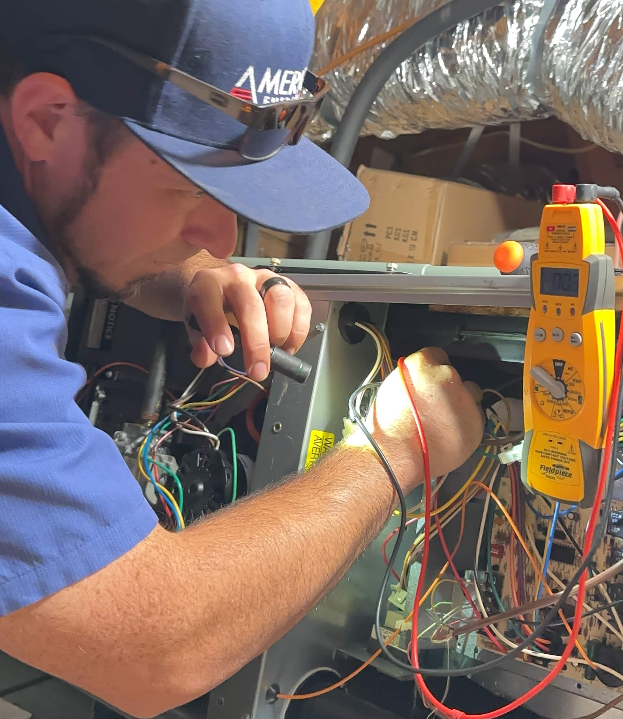 A heat pump in winter and fan blades, partially defrosted with snow and debris around it. A person uses tools to repair illustrating troubleshooting steps.