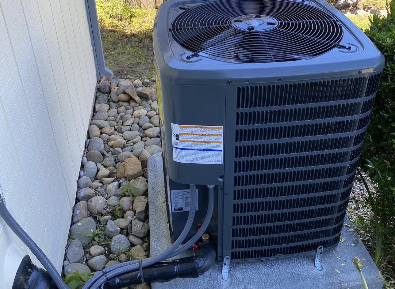 Newly installed outdoor AC condenser on a concrete pad beside a Sacramento home