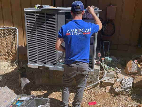 American Energy technician performing air conditioner maintenance in a side yard