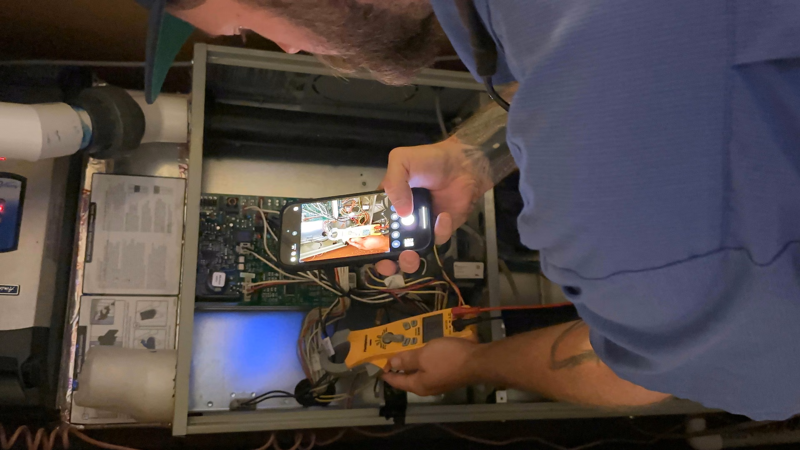 Technician hands testing a furnace control board with a meter