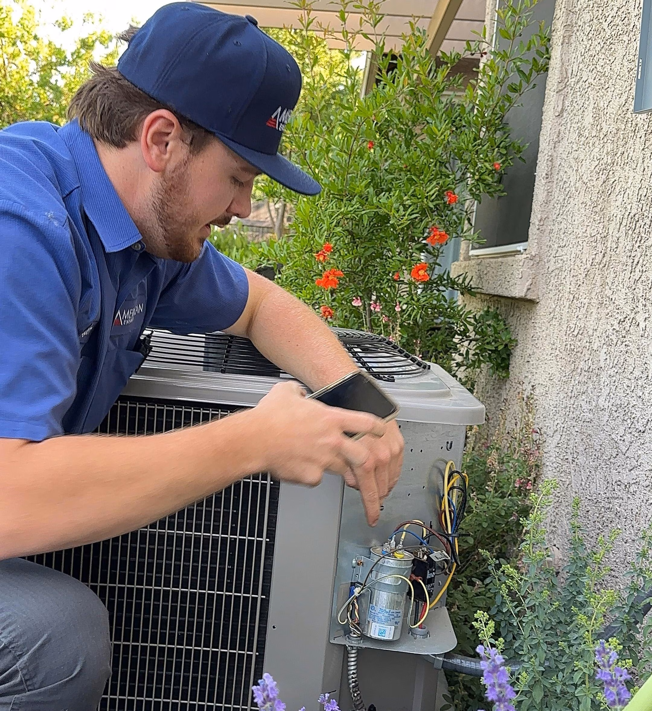 American Energy technician inspecting the top of an outdoor heat pump