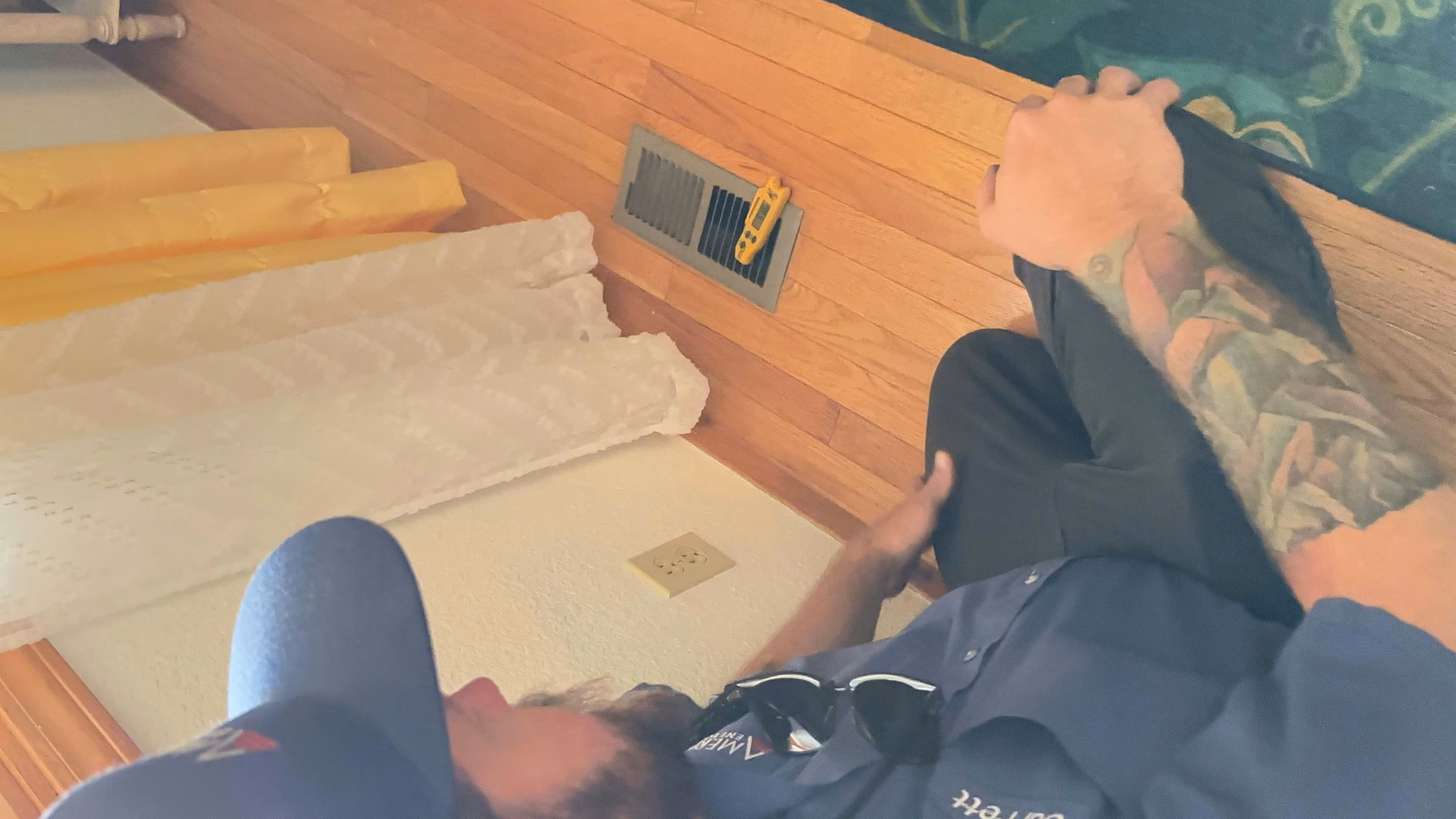 Technician kneeling on the floor to install indoor heat pump equipment