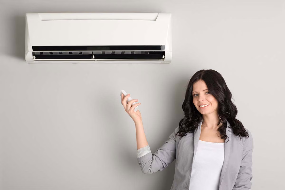 Woman gesturing toward a wall mounted ductless mini split system